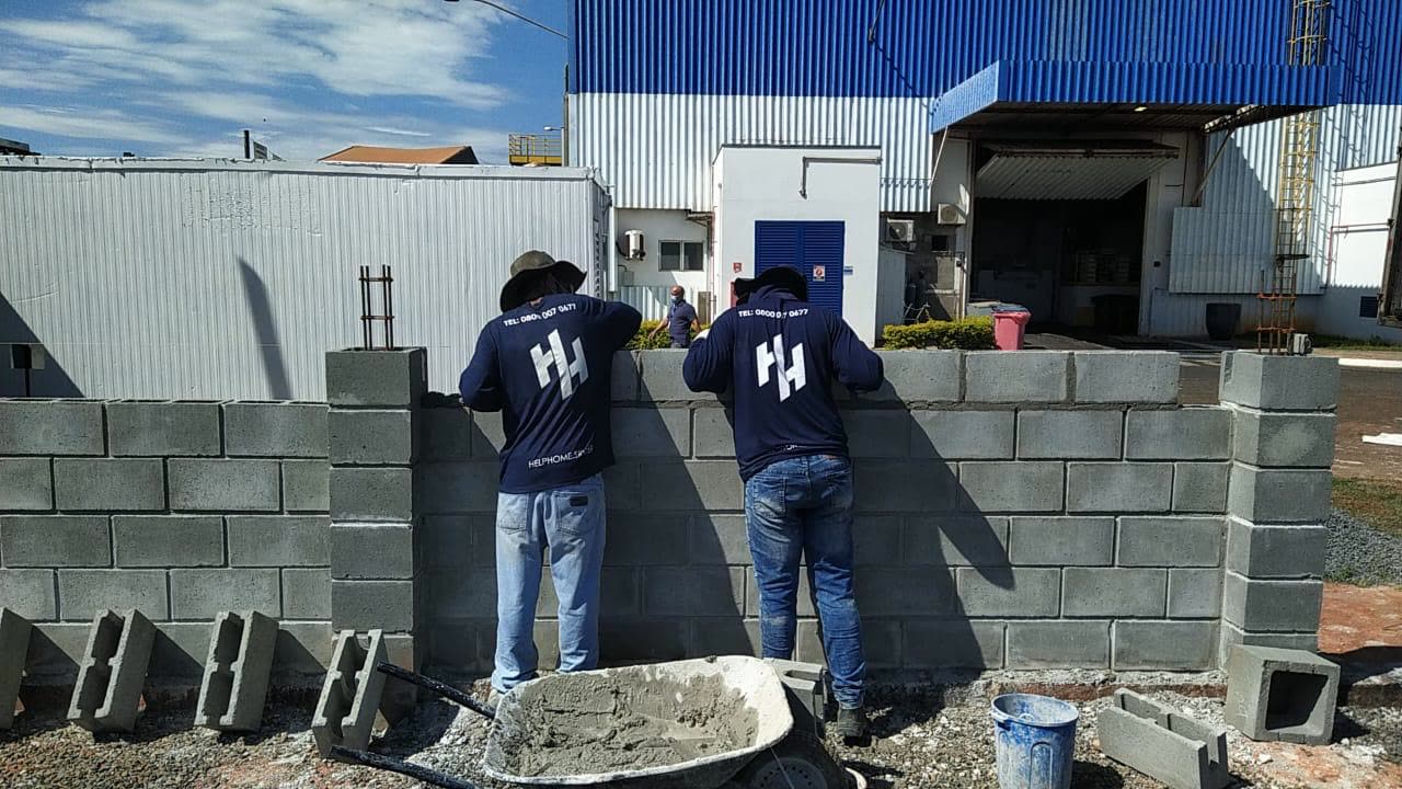 Equipe Help Home levantando parede de blocos de concreto
