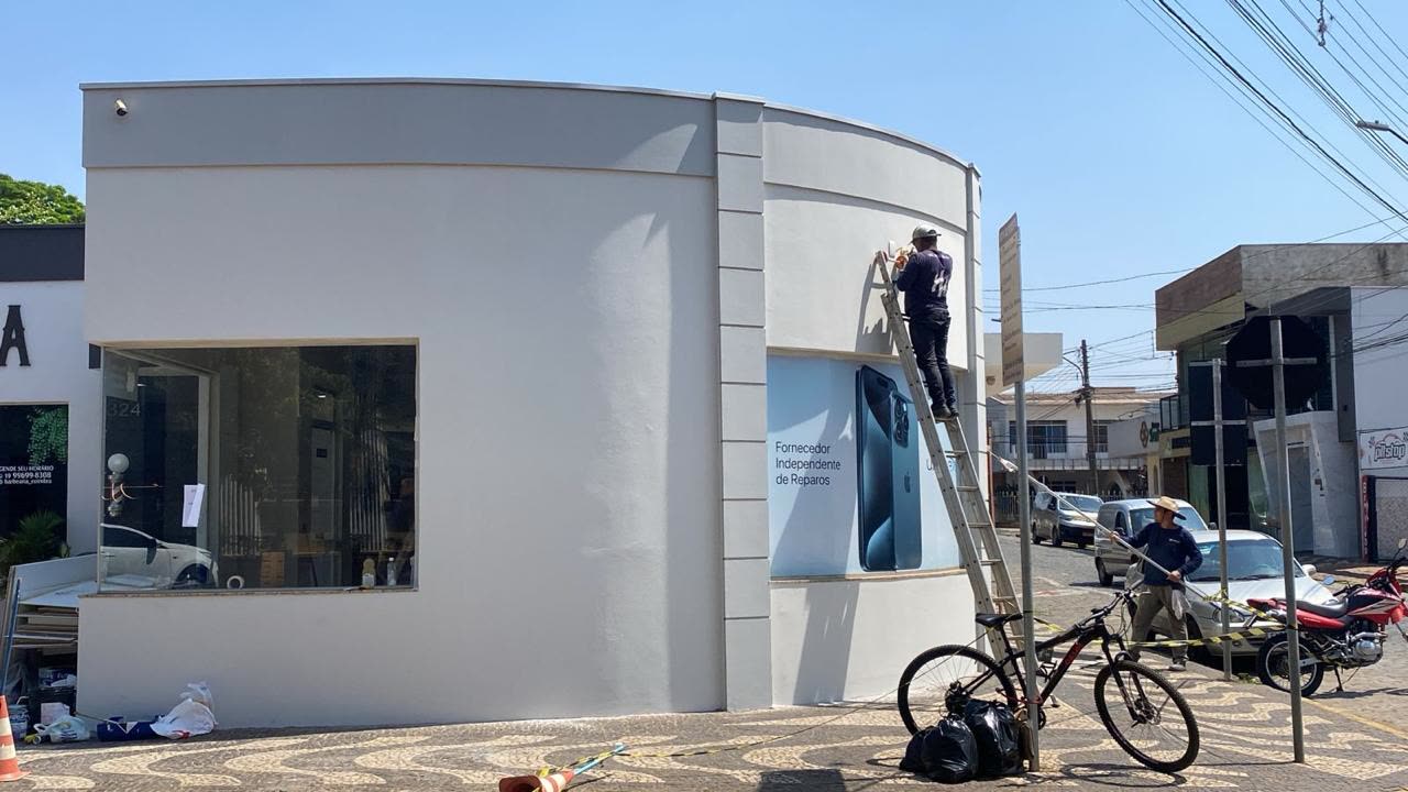 Pintor da Help Home na escada, pintando a fachada de uma loja